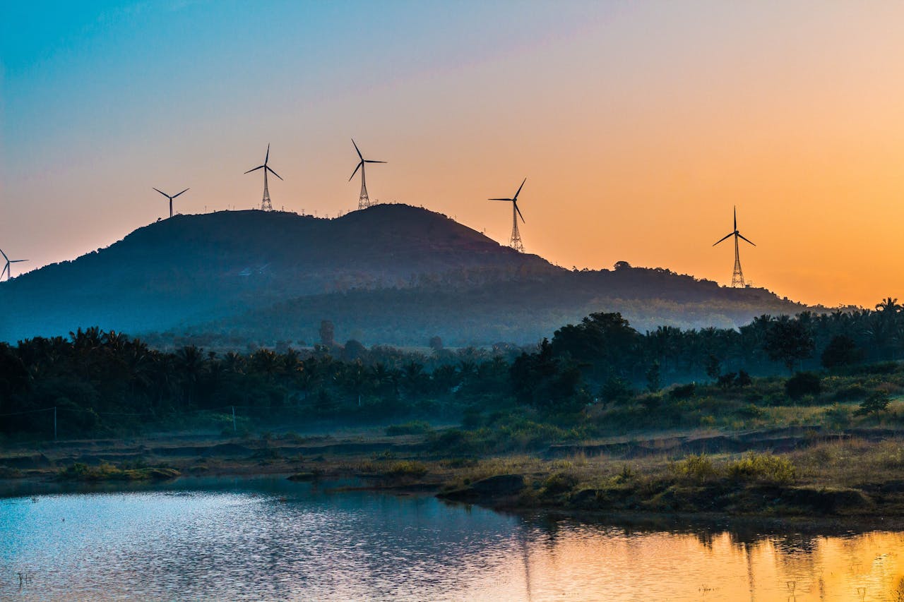Peaceful landscape of wind turbines on hills at sunset, emphasizing renewable energy.